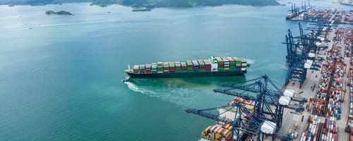 Cargo ship at port representing commercial trade risks